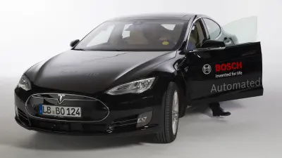 Michael Fausten steigt aus einem Tesla Versuchsfahrzeug.