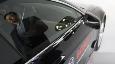 The image shows a driver in a connected car.