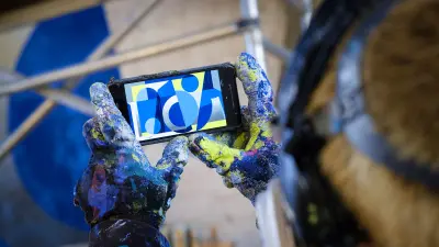 Roberto Rivadeneira takes a picture of his finished artwork, it can be seen through the smartphone display.