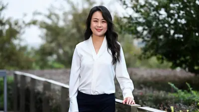 Jessica trägt eine weiße Bluse und lächelt in die Kamera.