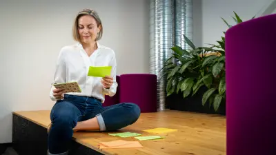 Karolina sits on a platform holding sticky notes in her hands.