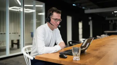 Hamza makes a video call using a headset.