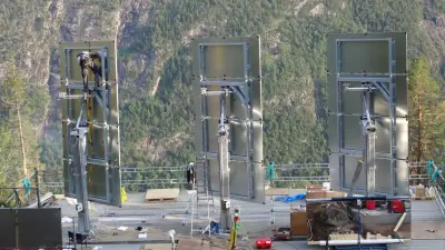 Three heliostats on the mountain being mounted.