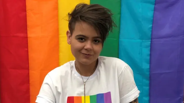 Das Bild zeigt Bosch Mitarbeiterin Caroline. Hinter ihr befindet sich eine Regenbogenflagge.
