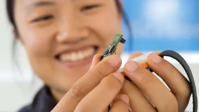 Bosch Systemingenieurin Kejia Wang mit einem Sensor.