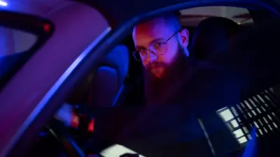 The world champion in the smartphone racing game "Asphalt 9" Florian Roschu sits in a car and looks into the camera. 