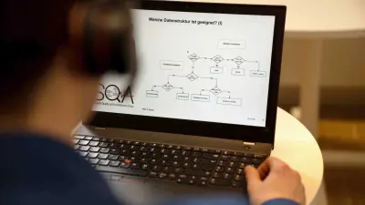Ein Laptop steht auf einem weißen Tisch. Auf dem Bildschrim ist eine Abbildung einer Datenstruktur zu sehen. Michael Huis Hand liegt auf dem Laptop.