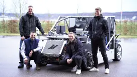 Tobias Ritz and his colleagues stand around a vehicle demonstrator for model predictive vehicle motion control research from Bosch Research.