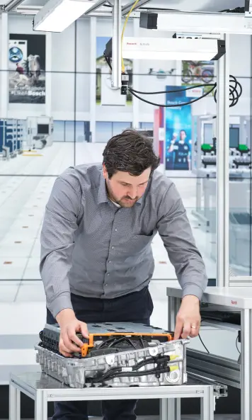 Bosch Research engineer Matthias Kayser at a test table at ARENA2036 preparing components for the camera-based image recognition on which the DeepInspect system is based.