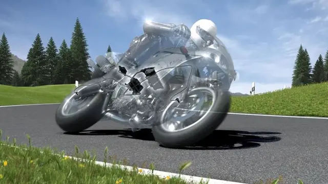 A motorcyclist in motorcycle clothing rides on a black motorcycle on a road.