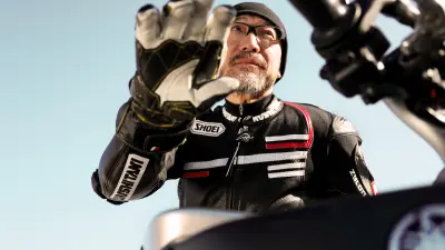 Motorrad-Journalist Kentaro Sagawa von unten fotografiert in Motorradkluft.
