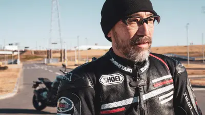 Kentaro Sagawa im Profil. Hinter ihm ein Motorrad.