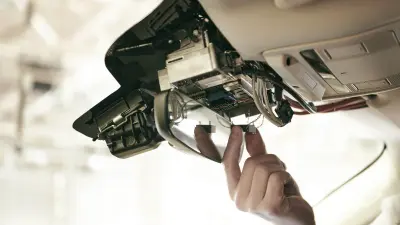 A view of a vehicle ceiling. The multifunctional camera is installed above the rear view mirror.