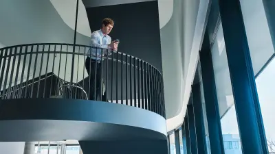 Florian Woelke is looking at his mobile standing on the stairs.