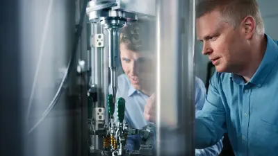 Florian Woelke and his colleague look at the prototype of ultrasonic self-piercing riveting.