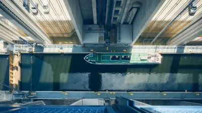 A green passenger boat in the water-filled trough of the Niederfinow boat lift, captured from a bird's-eye view.
