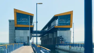Concrete ship lift structure with two glazed upper sections, walkways and a water channel.