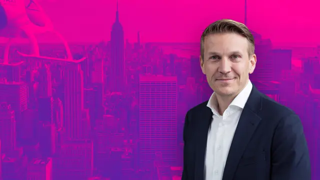 Christian Bauer in front of a violet wallpaper.