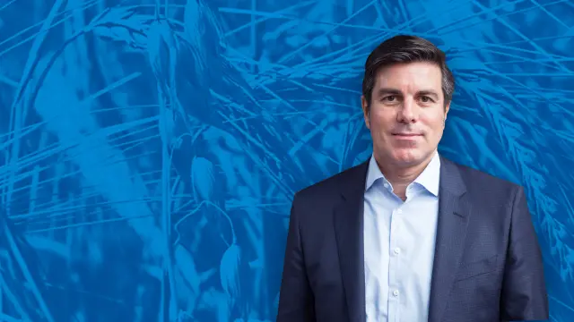 Jean-Marie Sol in front of a blue wallpaper.