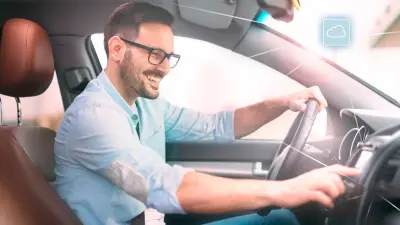Mann sitzt im Inneren eines vernetzten Fahrzeugs