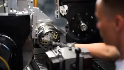 Emil Sauter, PhD student at Bosch Research, inserting a new part into a grinding machine.