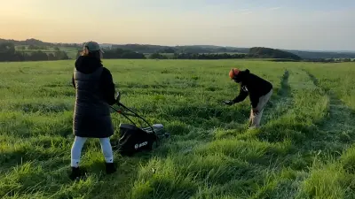 The cameraman and an assistant take a few shots of the lawnmower at dawn.