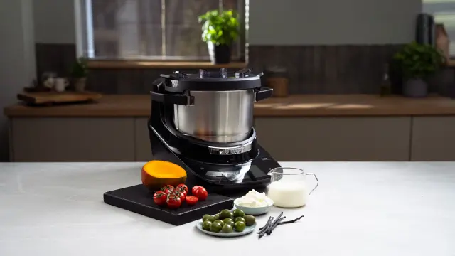 Der Bosch Cookit steht in einer Küche und ist umgeben von unterschiedlichen Zutaten.