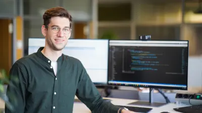 Sebastian Paul sitting in front of his computer with a green shirt