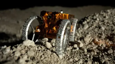 The CubeRover™ exploring a dusty, rocky lunar landscape.