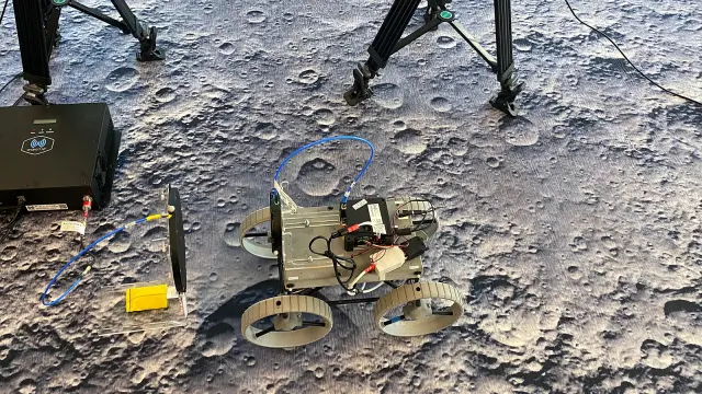 A CubeRover™ undergoing tests on an artificial lunar terrain with testing equipment.