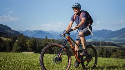 Reiner fährt auf einem Mountainbike hoch zur Hütte.