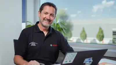 Reiner sitzt an seinem Schreibtisch im Bosch-Werk und arbeitet.