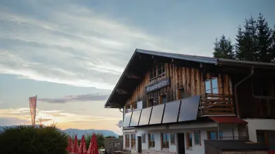 Zu sehen ist die Strausberghütte im Allgäu, im Hintergrund ist der Sonnenuntergang erkennbar.
