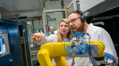 Two people examining equipment in an automated production cell.