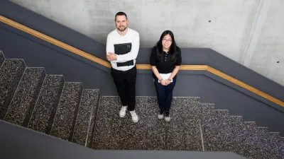 Allison Suba and Tobias Huschitt stand together on a staircase.