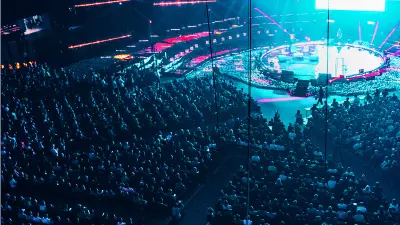 A huge Slush event hall with a big audience and a colorful illuminated stage.