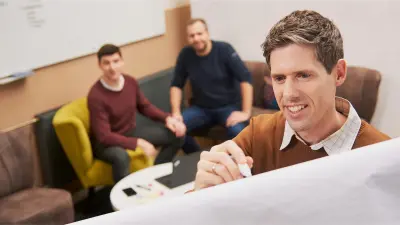 Martin Weiss writes on a flipchart during a meeting with some colleagues.