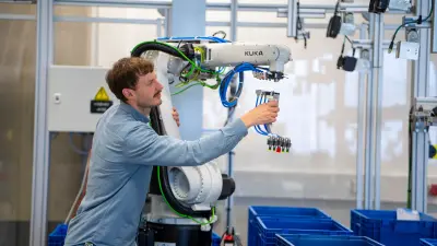 Auf dem Bild ist das Smart Item Picking System von Bosch Research und Bosch Rexroth in einem industriellen Umfeld zu sehen. Der Roboterarm greift ein Objekt vom Förderband.