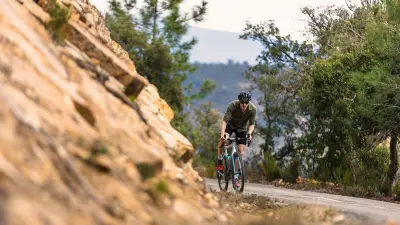 Extreme athlete Till Schenk climbs a mountain road.