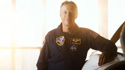 Michael Foale lehnt neben einem Leichtflugzeug in einem Hangar.