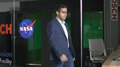 Samarjit Das trägt Anzug und Brille und geht durch ein Büro.