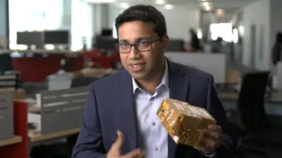 Samarjit Das trägt einen Anzug und hält einen Prototyp von SoundSee in der Hand.