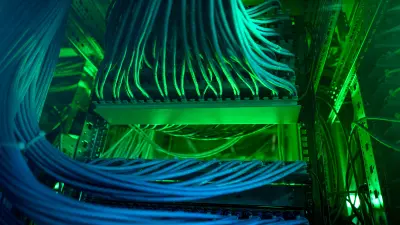 Blick auf grün und blau beleuchtete Kabelstränge in einer Core Site der Deutschen Telekom.
