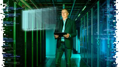 Bernd Schulte-Sprenger, Vorsitzender der Geschäftsführung der PASM, steht in einer Core Site der Deutschen Telekom, hat ein iPad in der Hand und schaut auf ein ins Bild eingefügtes Hologramm stationärer Brennstoffzellen, das deren digitalen Zwilling darstellt.