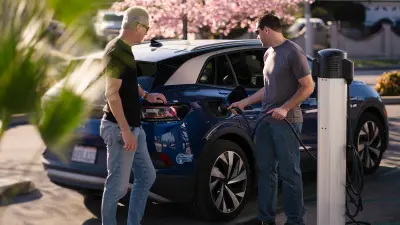 Michael Johnson, municipal services director for the city of Ontario, California, with Jeff Bartel, business development manager at Climatec. The two stand in front of a charging station, while Johnson recharges his electric car.