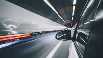 A car driving through a tunnel; the other vehicles are only recognizable as blurred lights. 