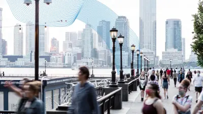 Im Vordergrund sind Menschen unscharf vor einer Skyline im Hintergrund erkennbar.