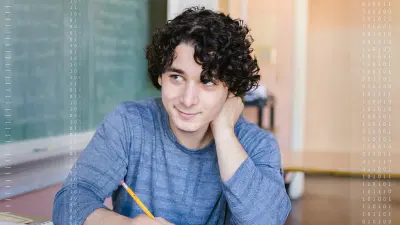 Ein Schüler sitzt lächelnd in einem Klassenzimmer, bereit für kreatives Lernen.