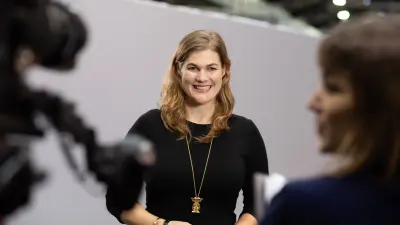 Catharina van Delden laughing, foreground out of focus: Camera, reporter