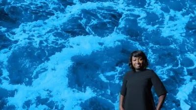 Kala Fleming vor einem dunkelblauen Hintergrund aus Wasser.